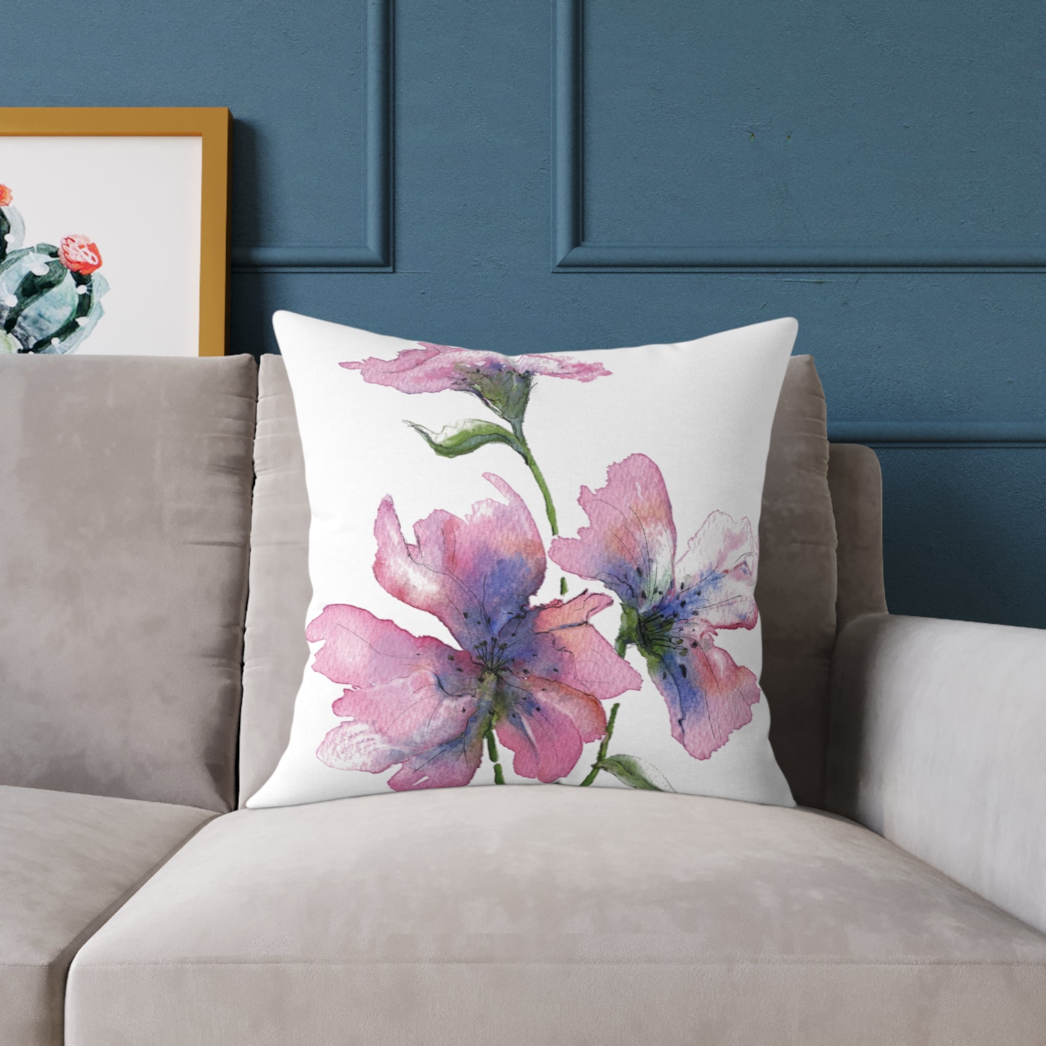 Floral pillow on a couch against a blue wall