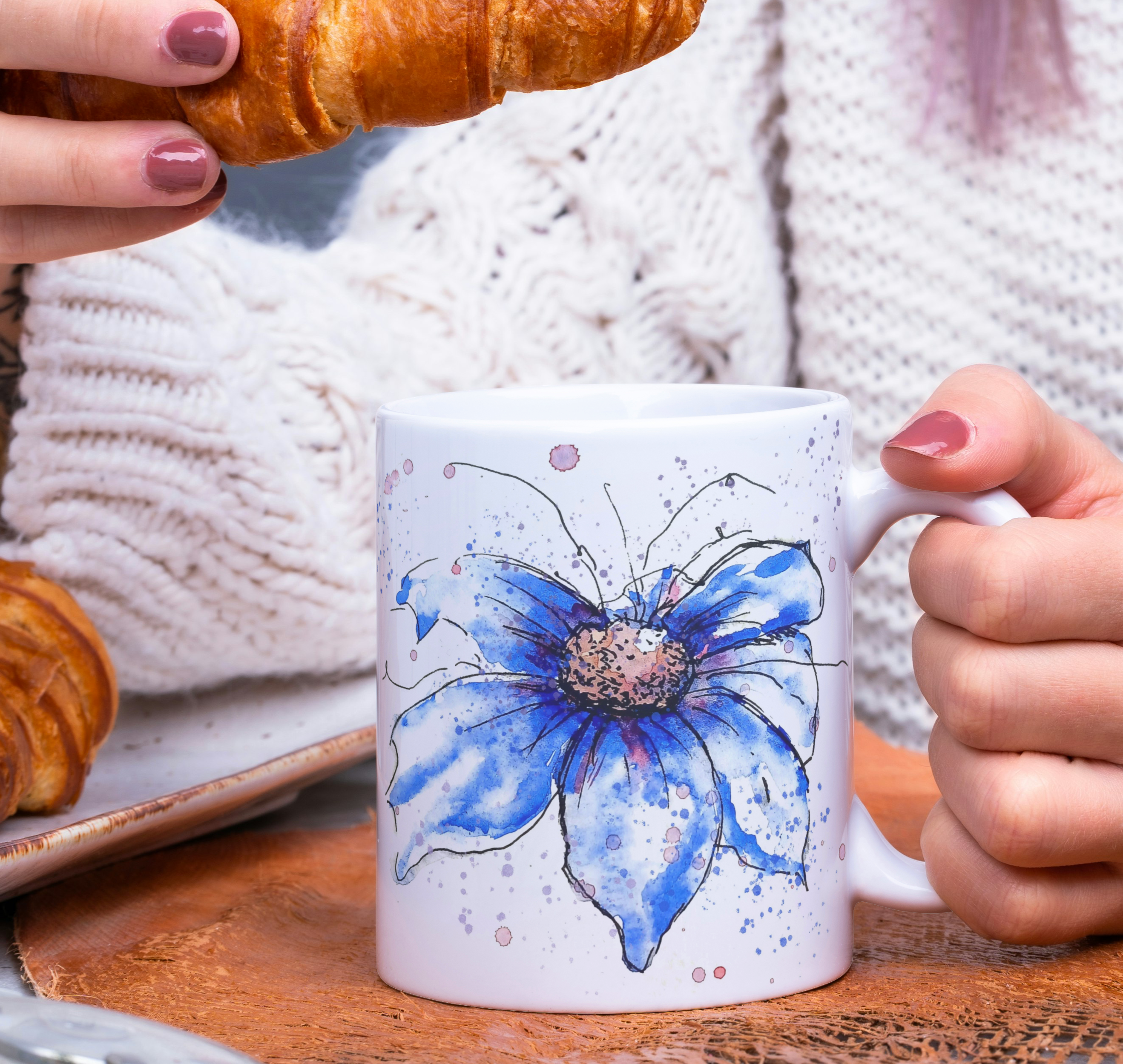 Blue cosmos watercolour mug with croissants and cozy sweater in morning breakfast scene
