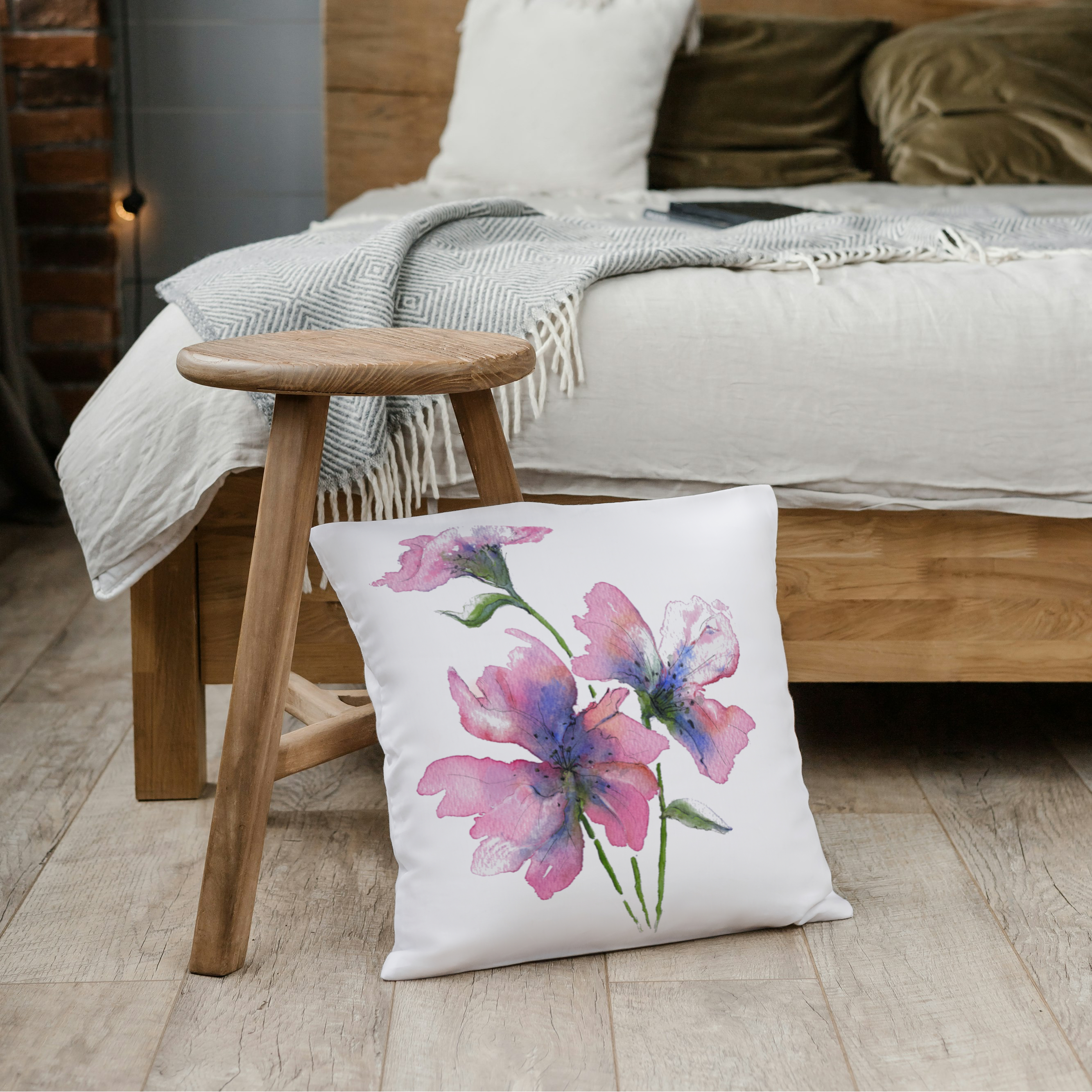 Bedroom setting with pink floral cushion leant against a wooden stool