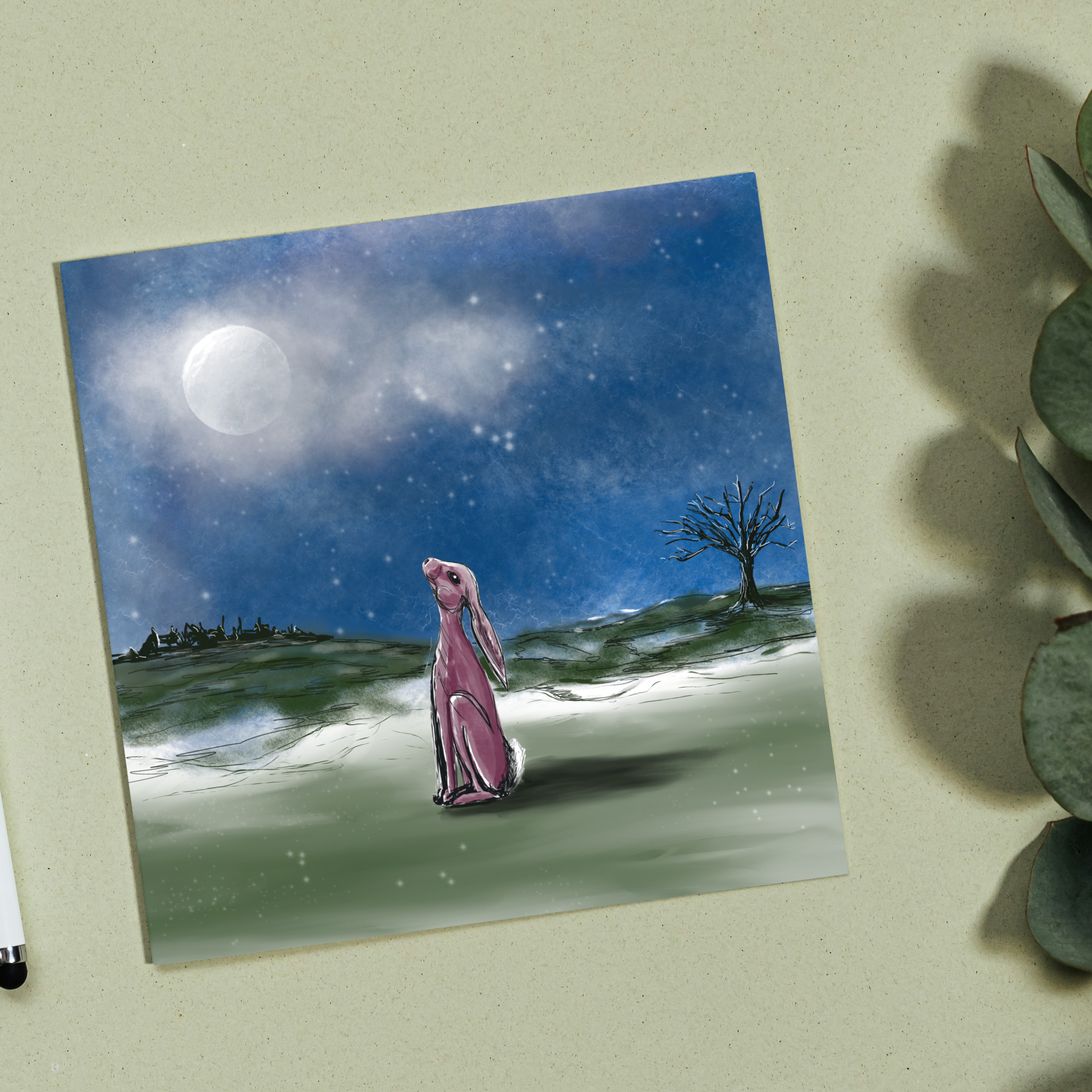 Stargazer Hare card on a pale table top with green foliage 