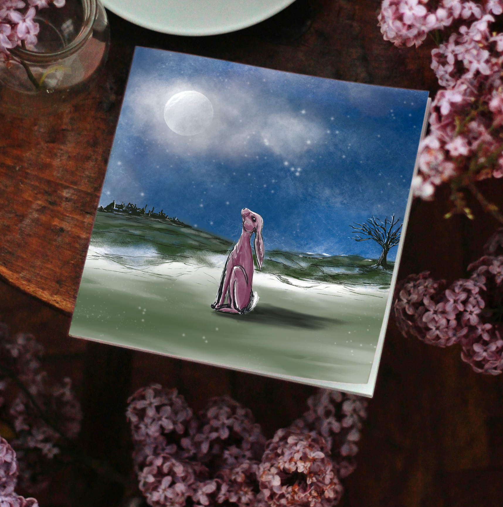 Stargazer Hare greeting card on a wooden surface with pink flowers 