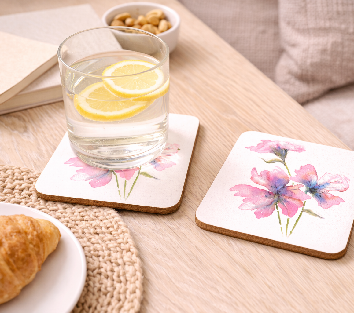 Coasters with floral design on a table with a glass of water and lemon slices.