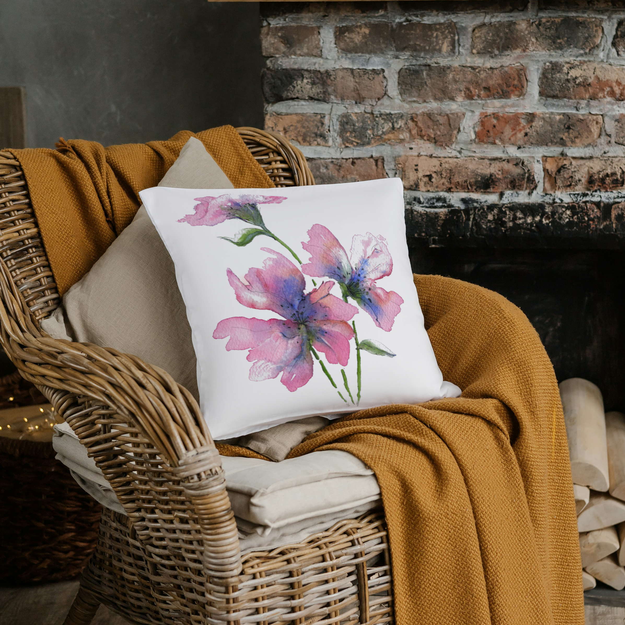 Floral watercolour gentle bloom cushion on a burnt orange throw next to brick fireplace 